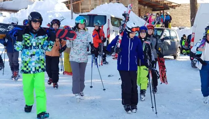 Skupina dětí s lyžemi před hotelem na Špičáku