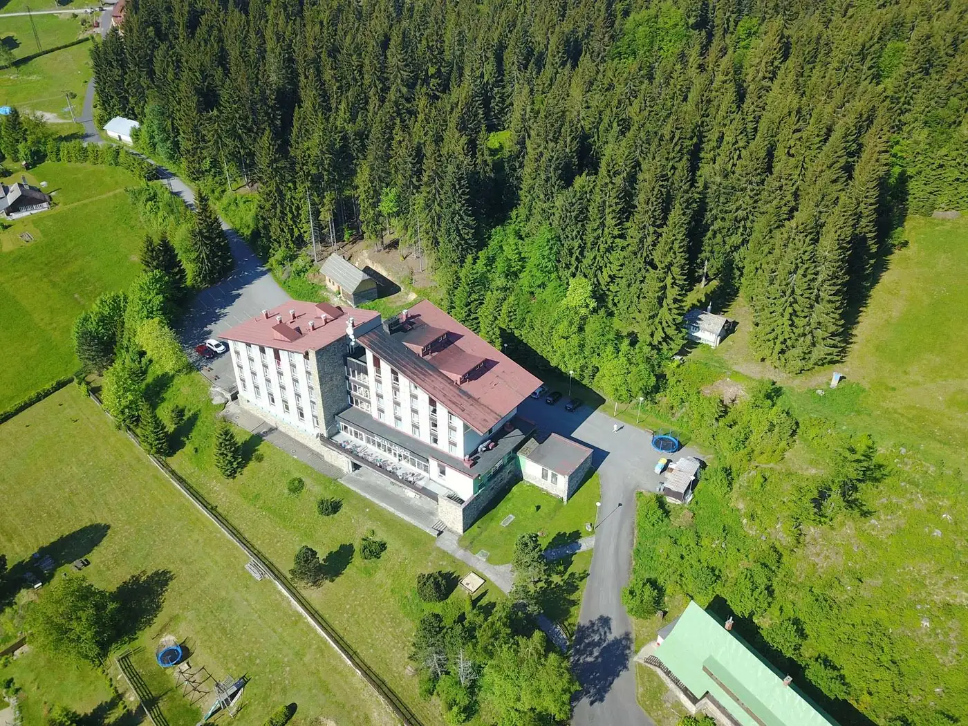Hotel Zadov v letní krajině centrální Šumavy
